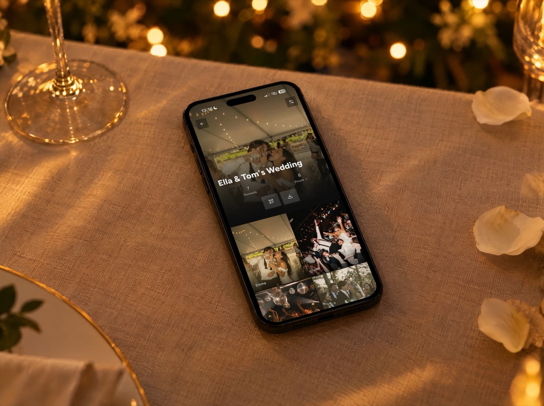 En iPhone på et duket bryllupsbord i kveldslys. Skjermen viser Unveil-appen: et delt bryllupsalbum med bilder tatt av gjestene.